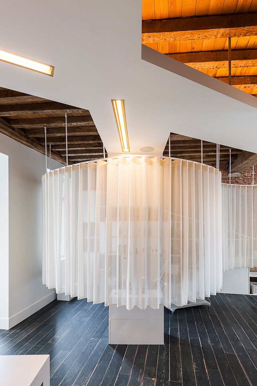 White ceiling, lighting with golden glint and smart design transform the industrial space