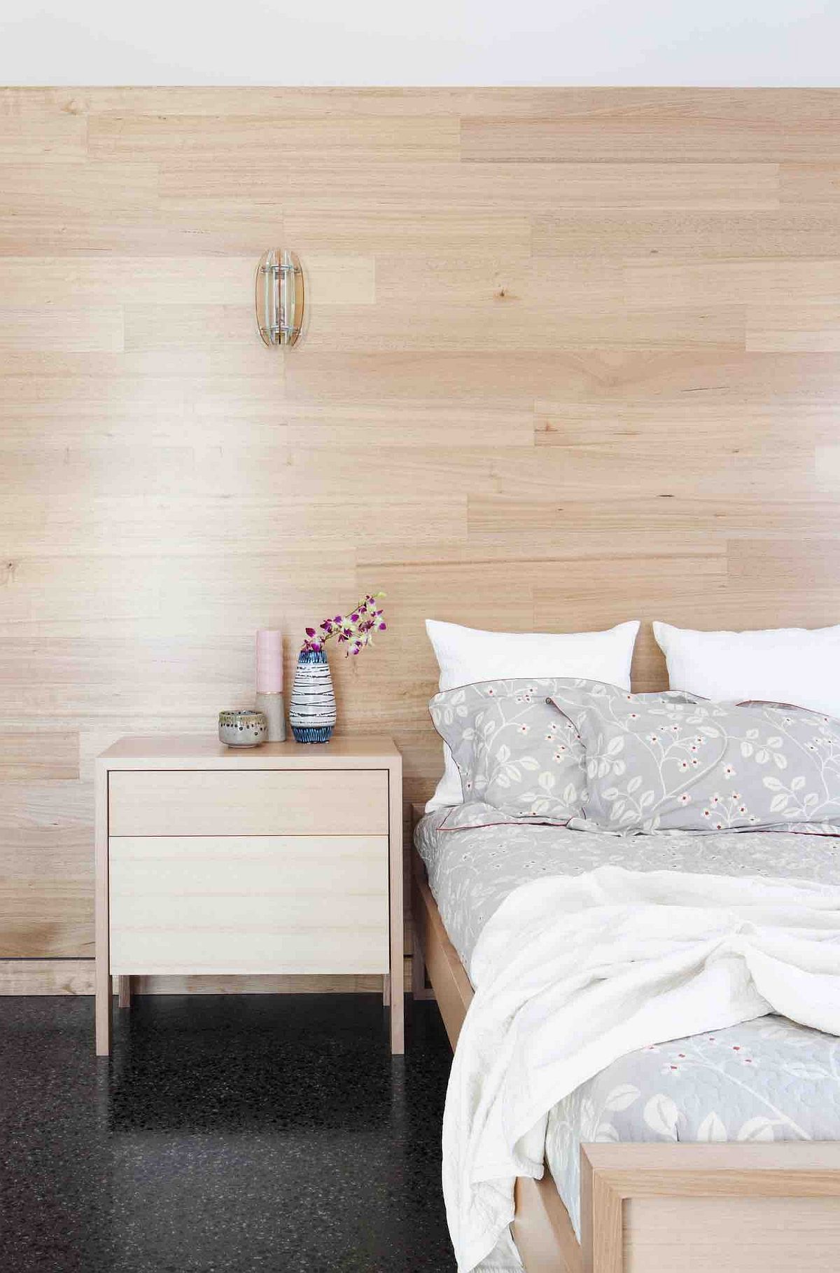 Wooden walls give the bedroom a cozy Scandinavian look