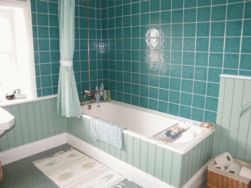 A bathroom that is a blend of different turquoise hues