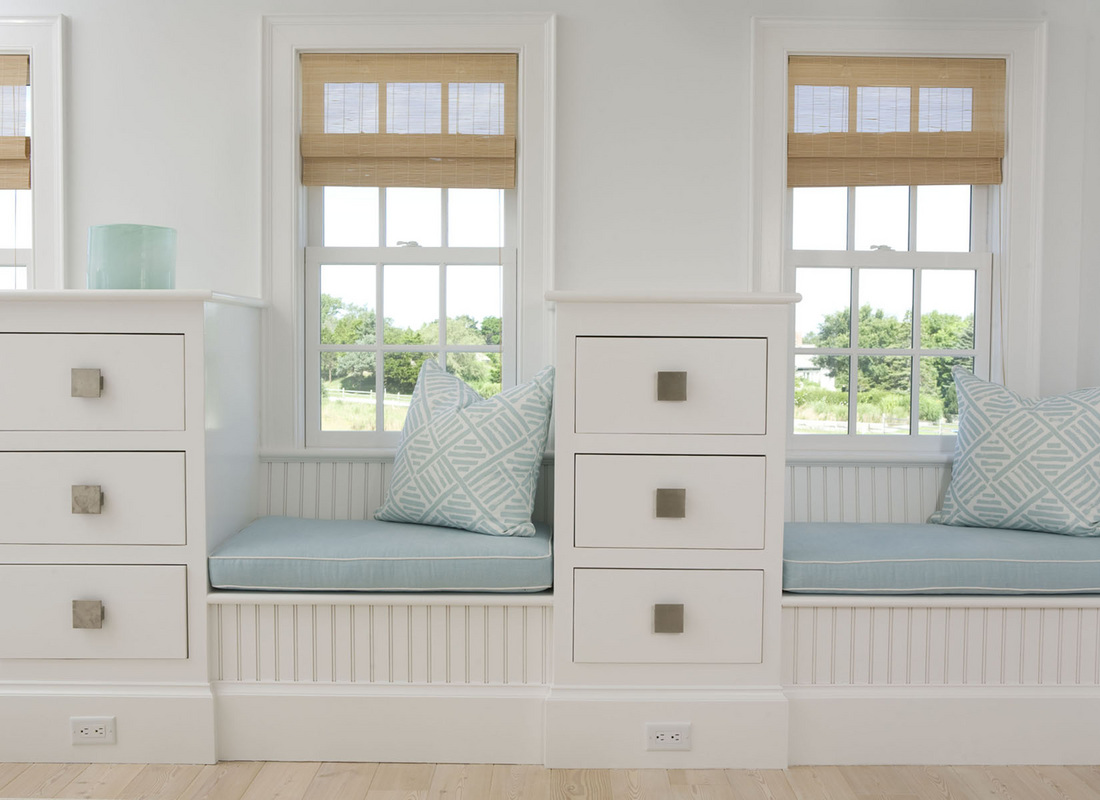 A double window seat in soft pastel hues