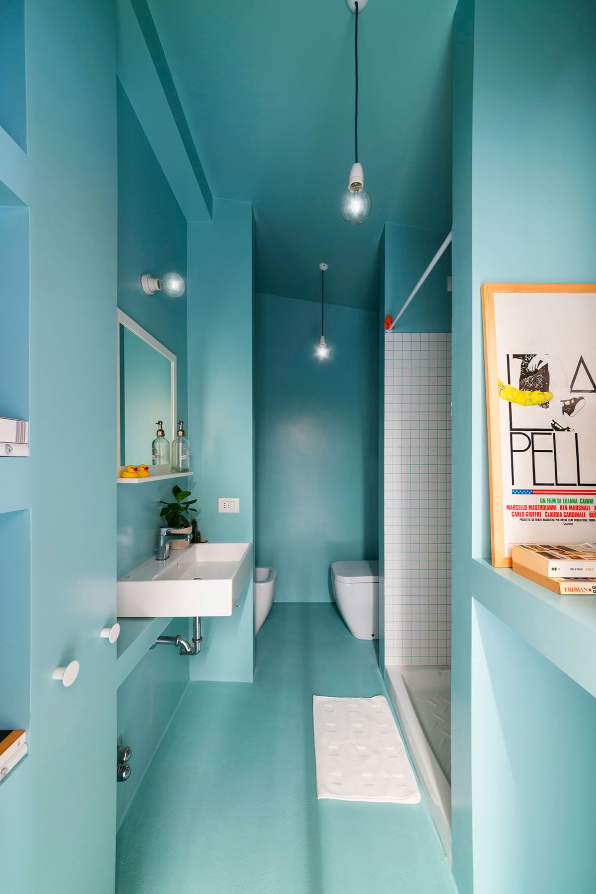 A narrow turquoise bathroom