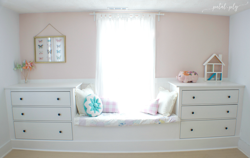 A small window seat in soft pastel colors