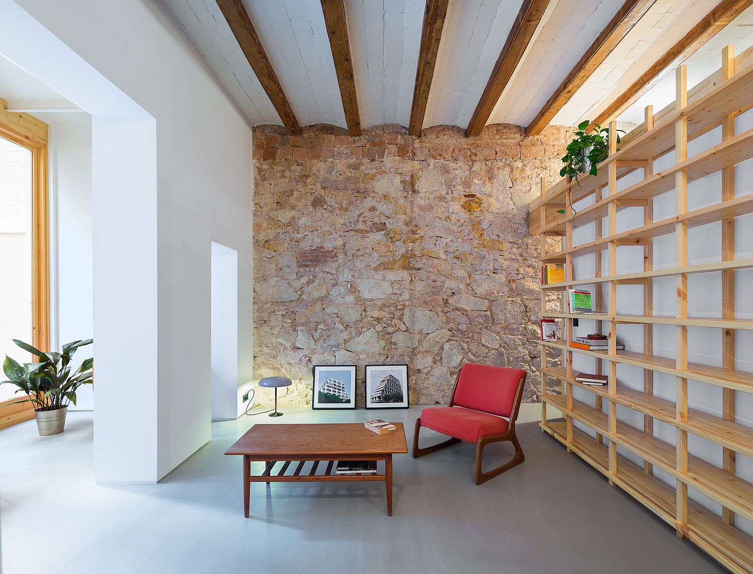 Existing walls and ceiling wooden beams bring in original charm of the Barcelona apartment