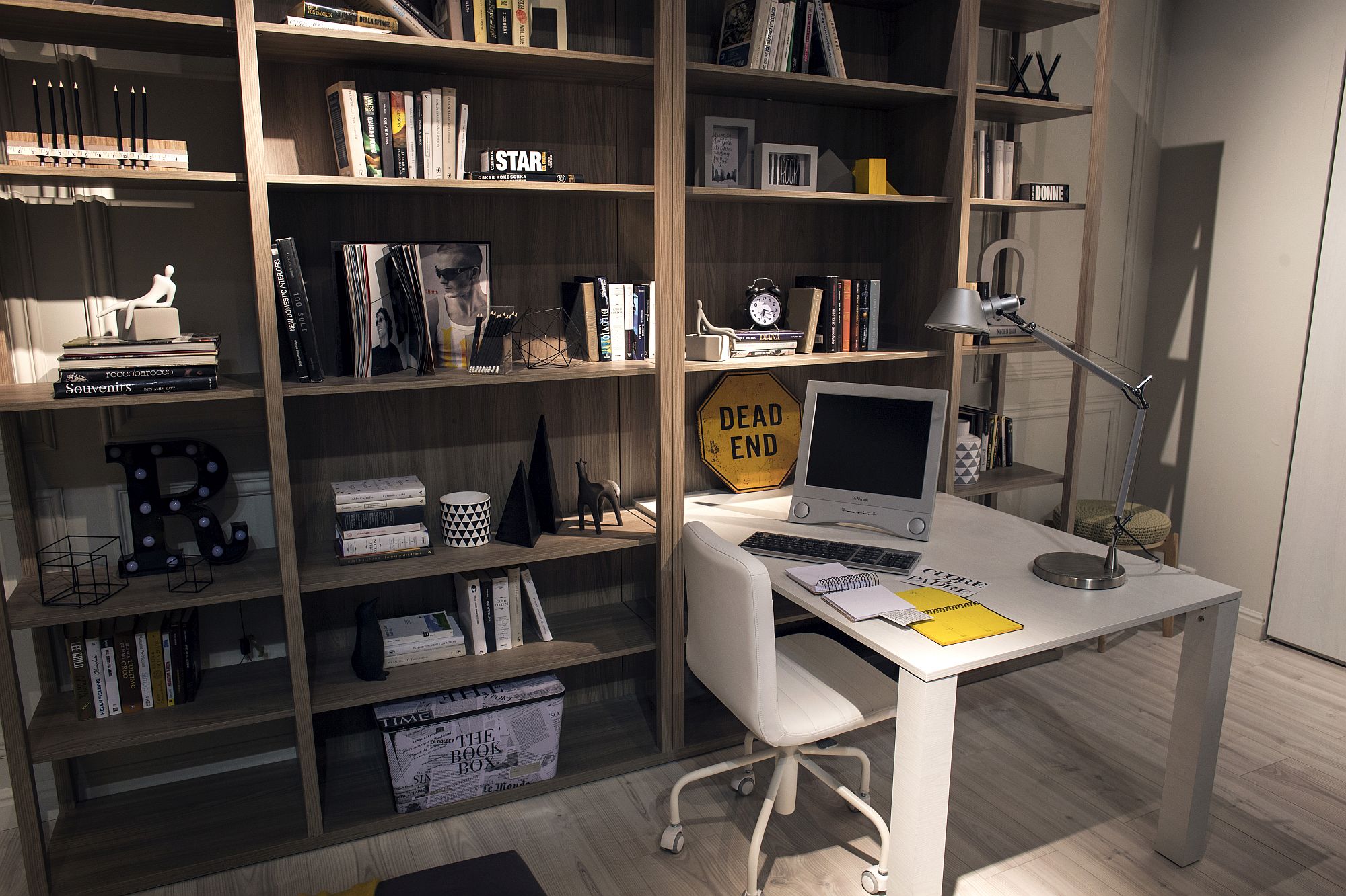 Floor-to-ceiling wooden shelving next to the ultra-slim desk in the kids' room