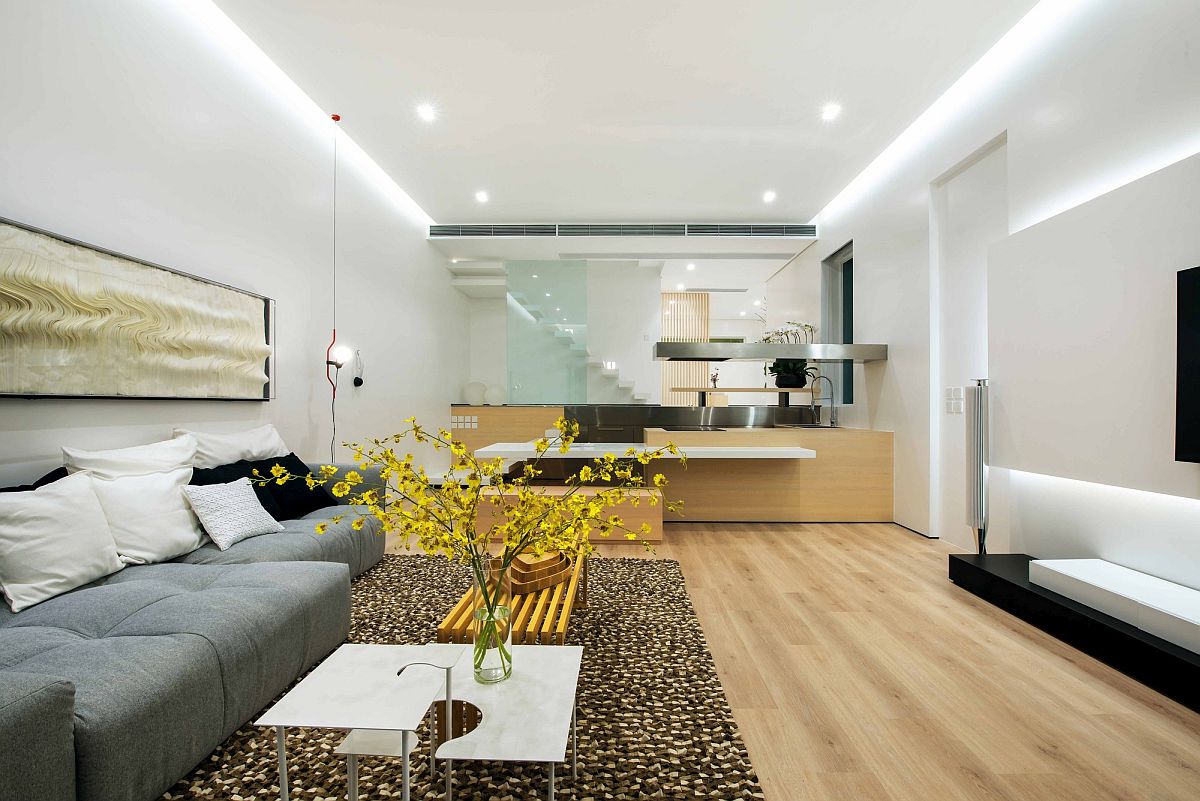 Living room in neutral hues with stylish contemporary kitchen next to it