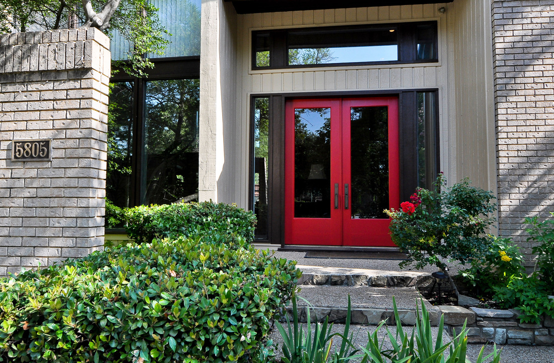 Modern red french doors outshine the rest of the exterior