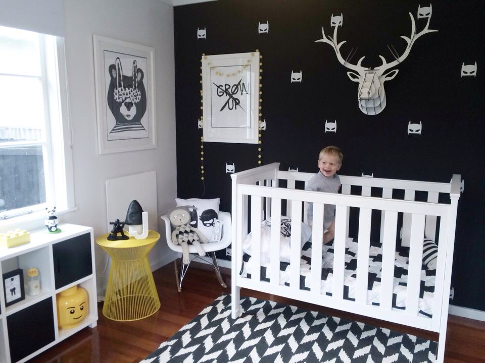 Monochrome nursery with a black wall and contrastin white pieces