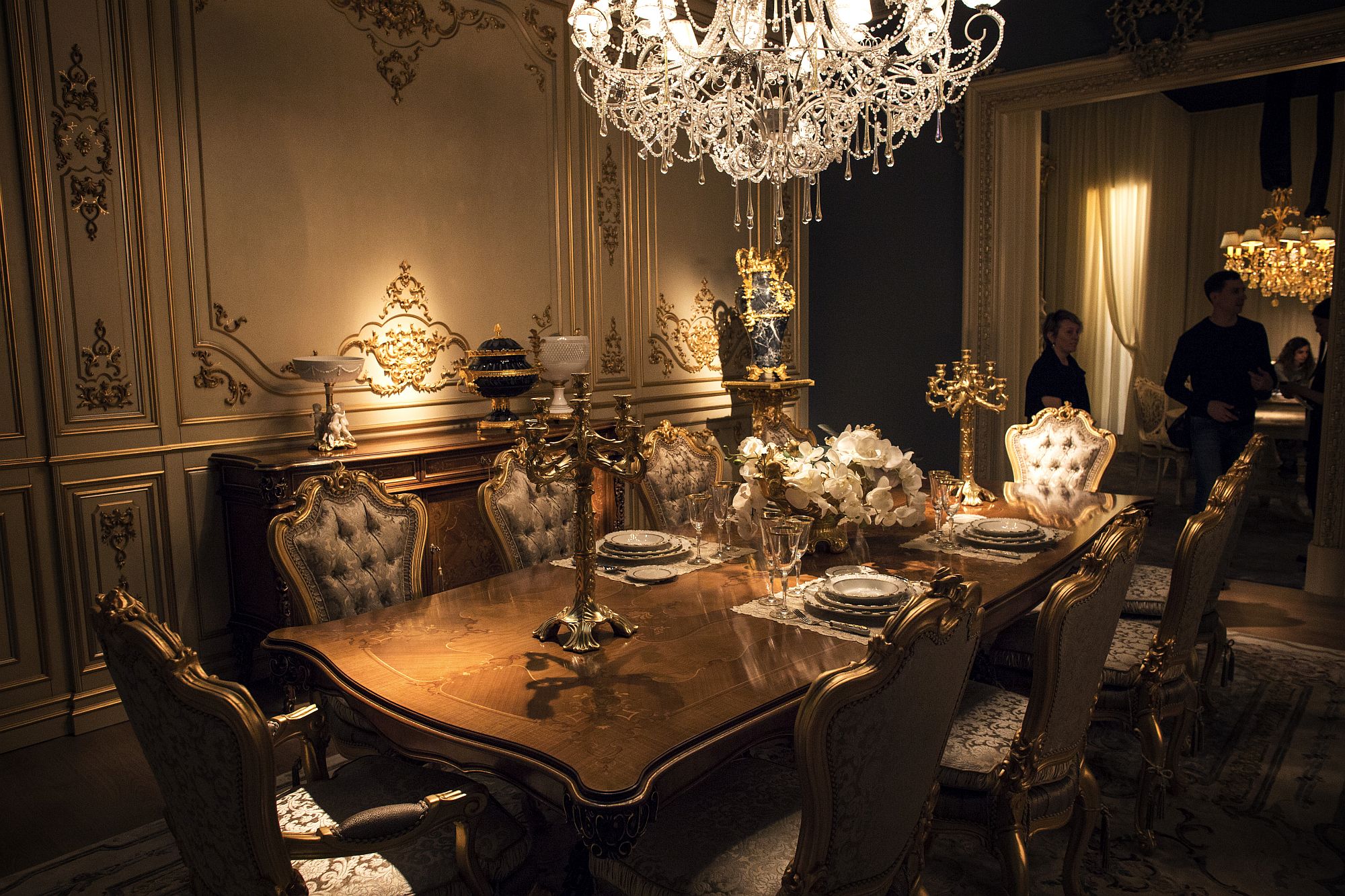 Opulent Victorian style dining room in gold and white with a sparkling chandelier