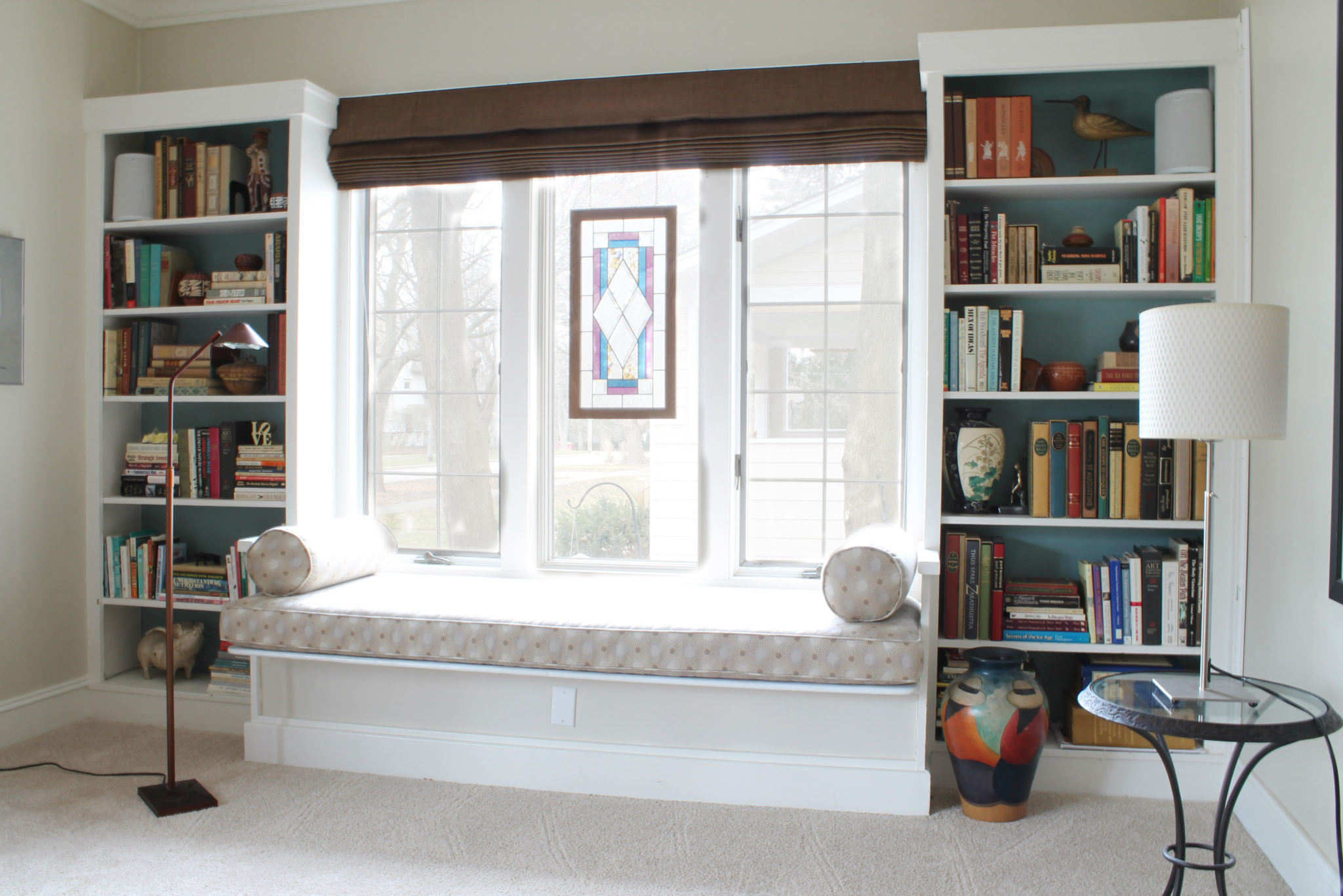 Simplistic window seat balances the space between bookcases