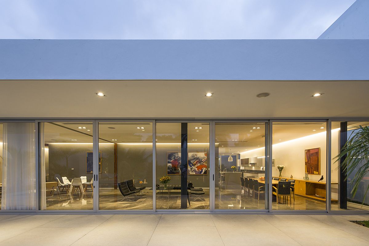 Sliding glass doors connect the interior with the pool space outside