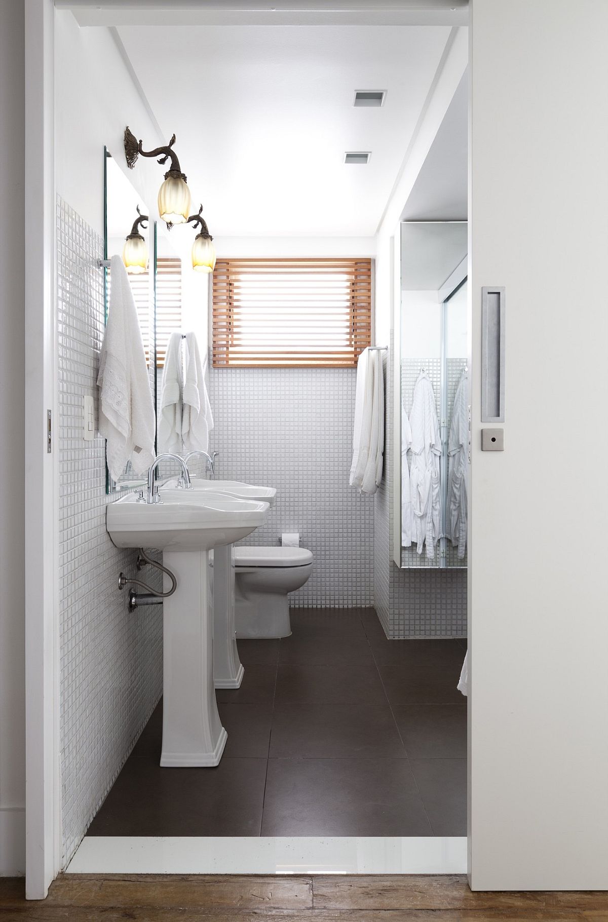 Space-savvy modern bathroom in white with dark flooring