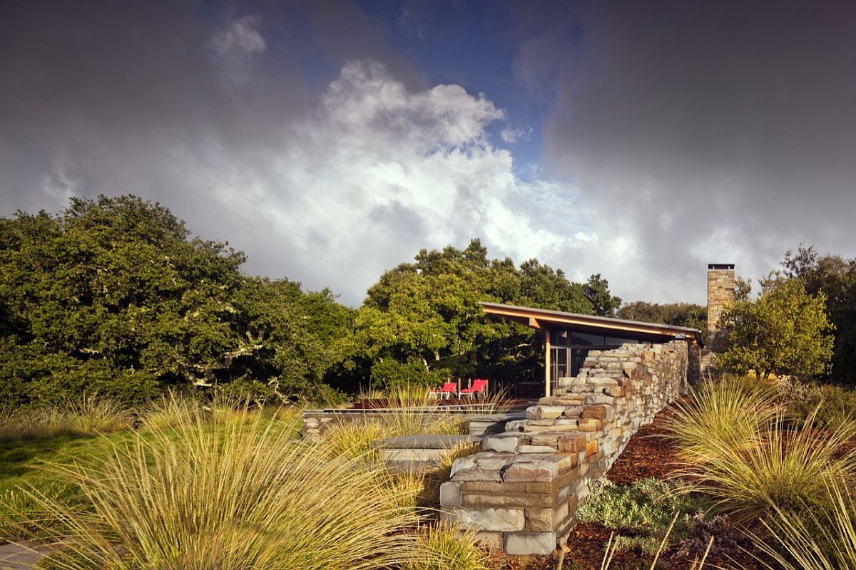 Stone wall acts as the boundary between the guest house and the untamed landscape