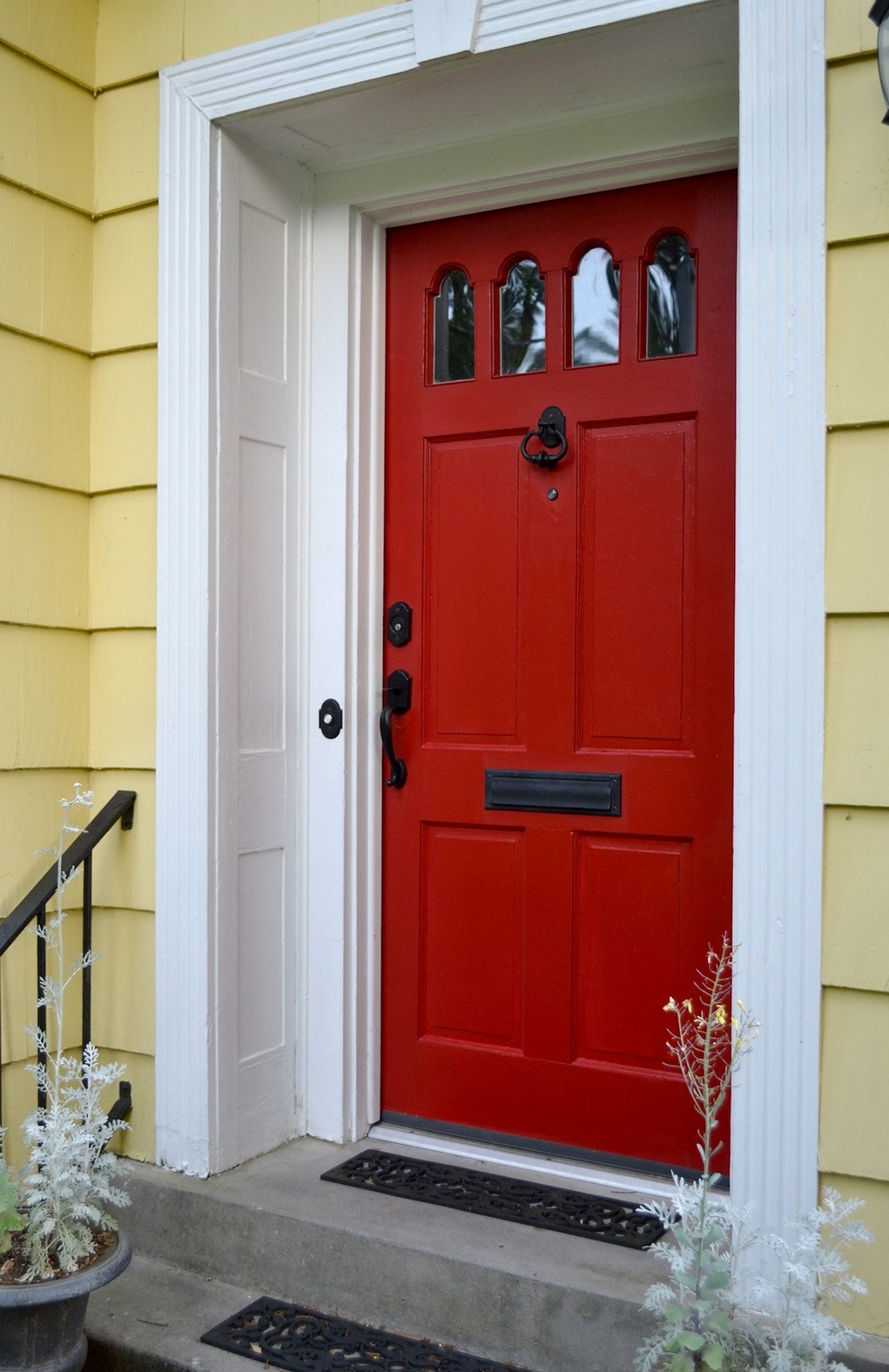 The bold red door enhances the pastel exterior