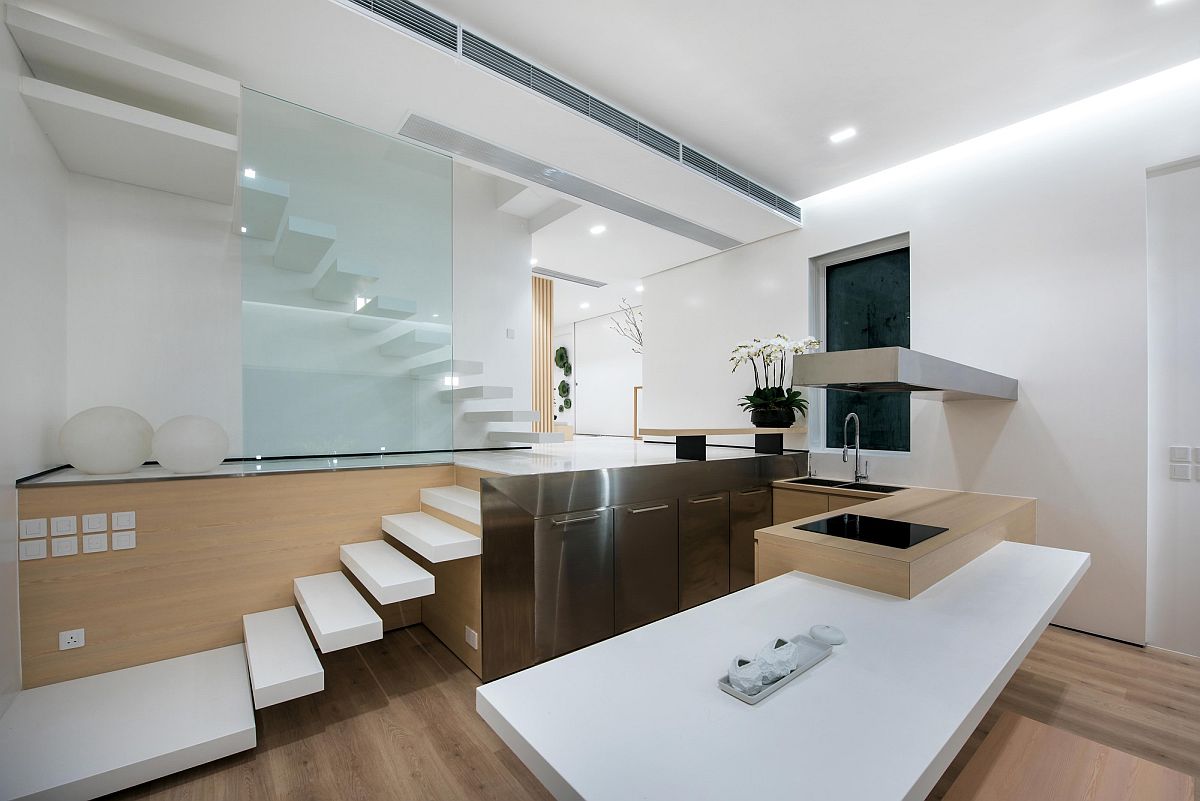 Ultra-minimal floating staircase next to the small. minimal kitchen