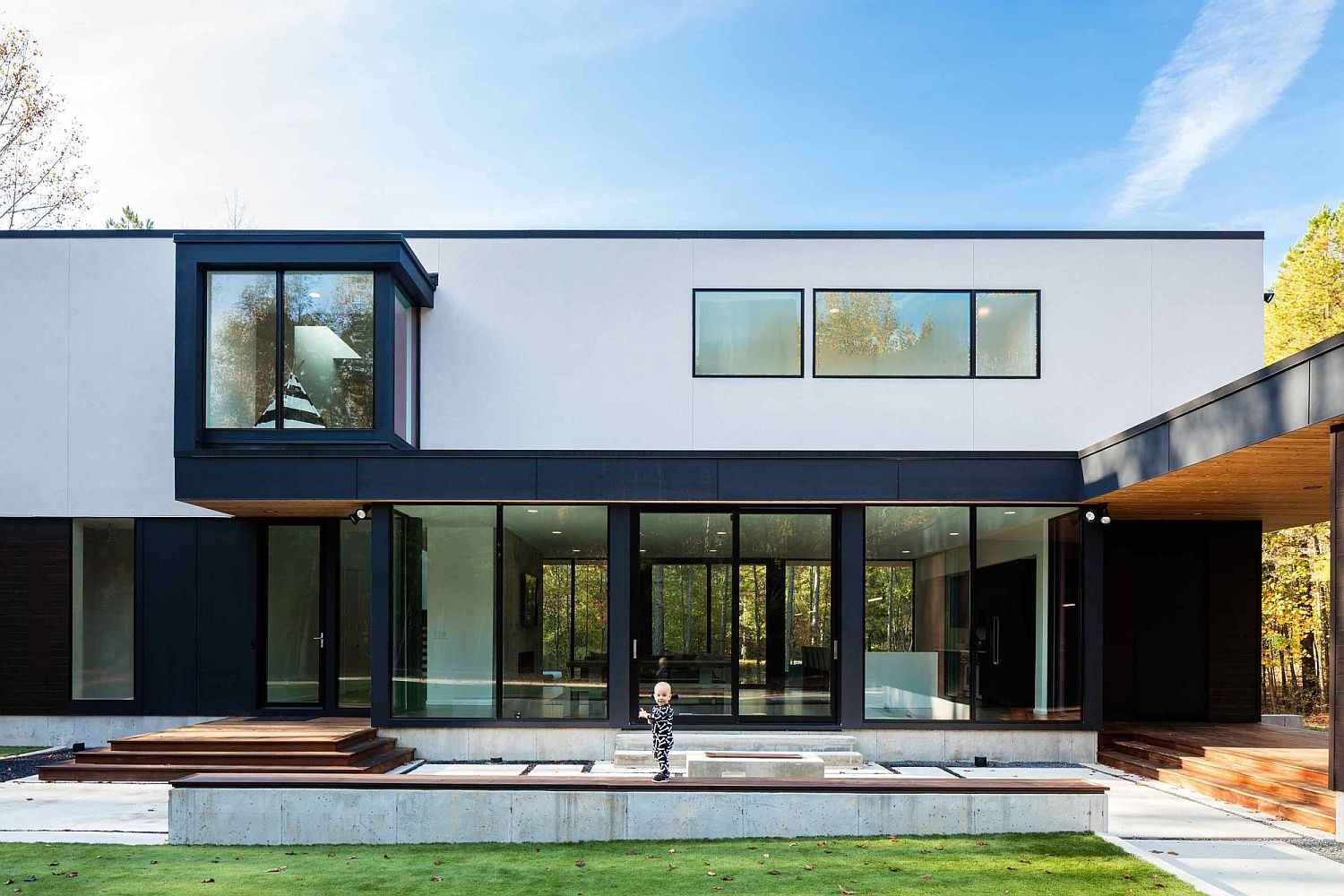 Dark window and door frames help anchor the white contemporary home