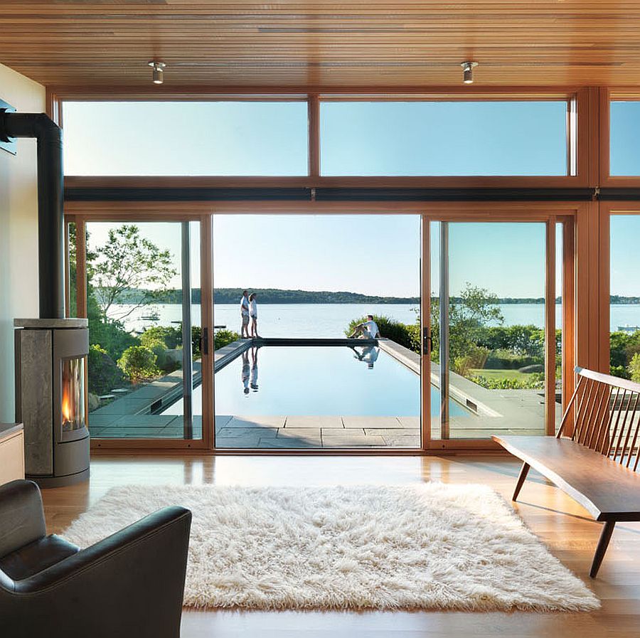 Glass and wood pavilion with lap pool and scenic coastal view beyond