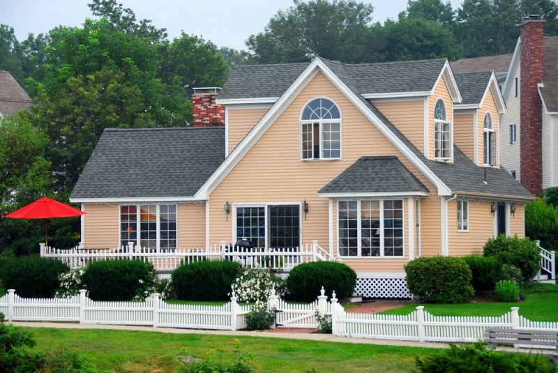 Grand peach house with a white picket fence