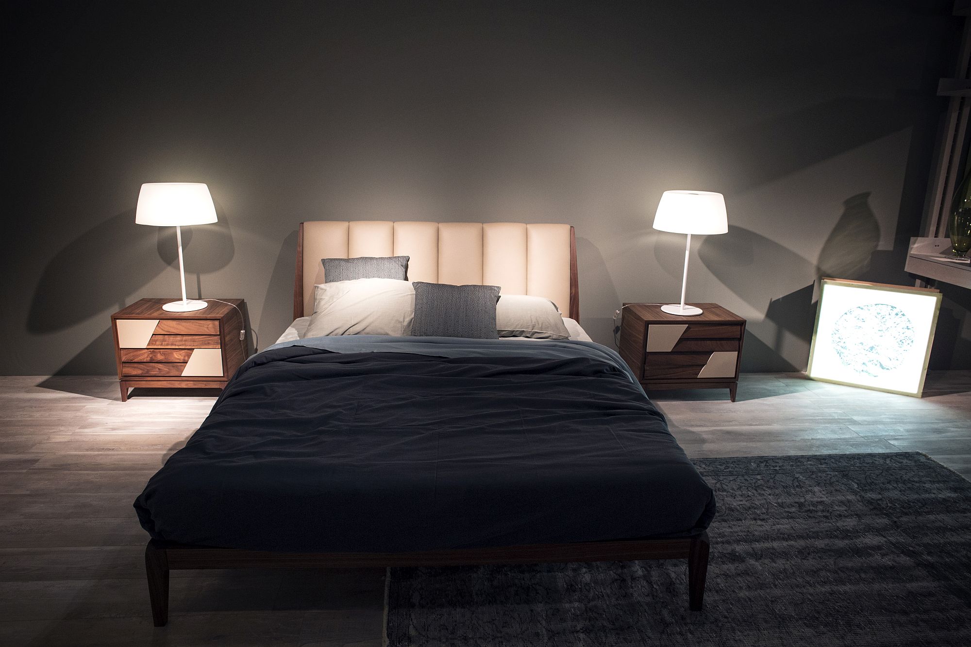 Matching wooden nightstands along with table lamps bring symmetry to the bedroom