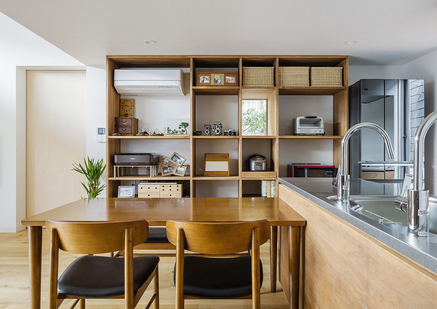 Open shelves in the backdrop of the kitchen and dining area