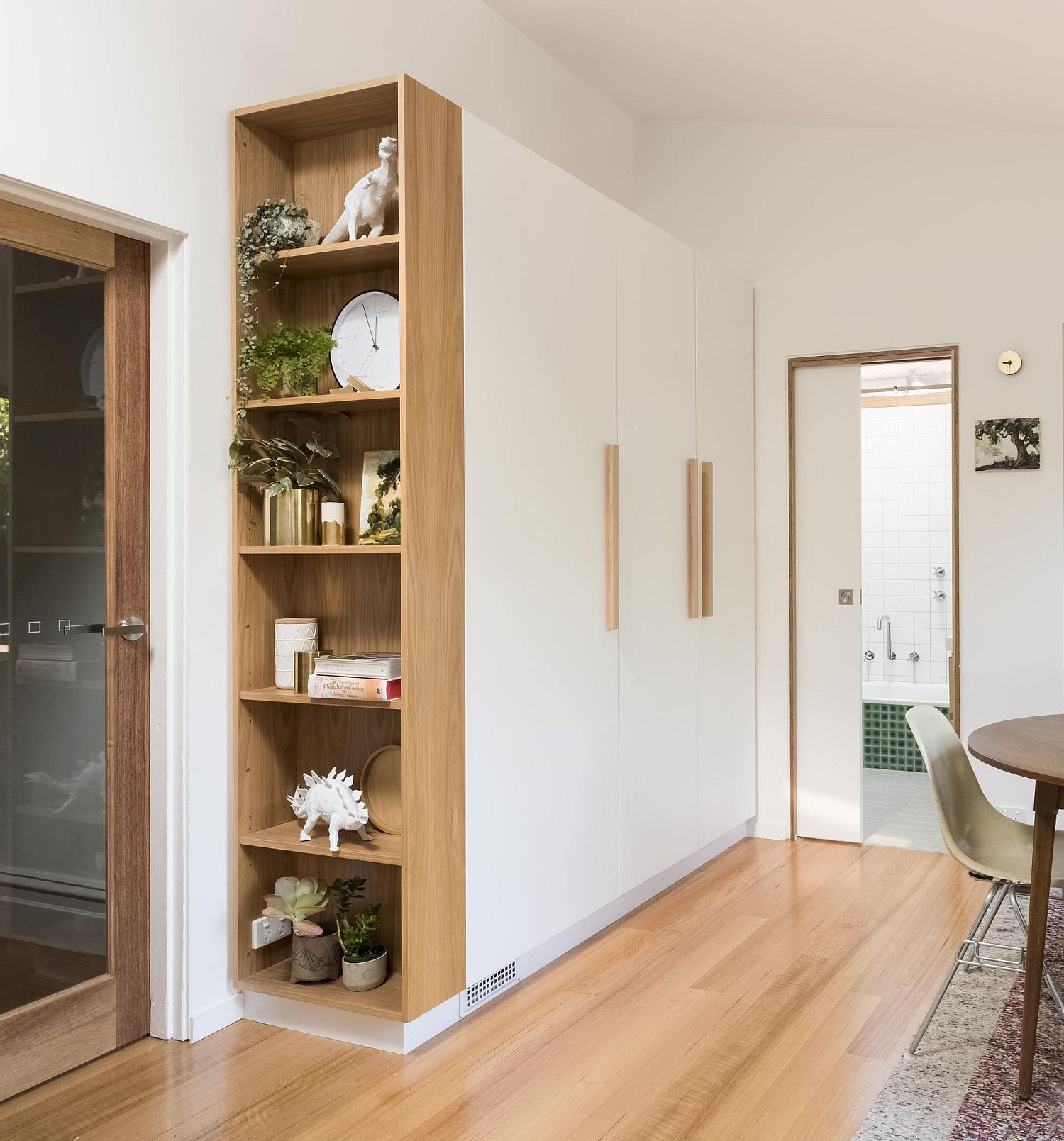 Open wooden shelf next to the large cabinet in white