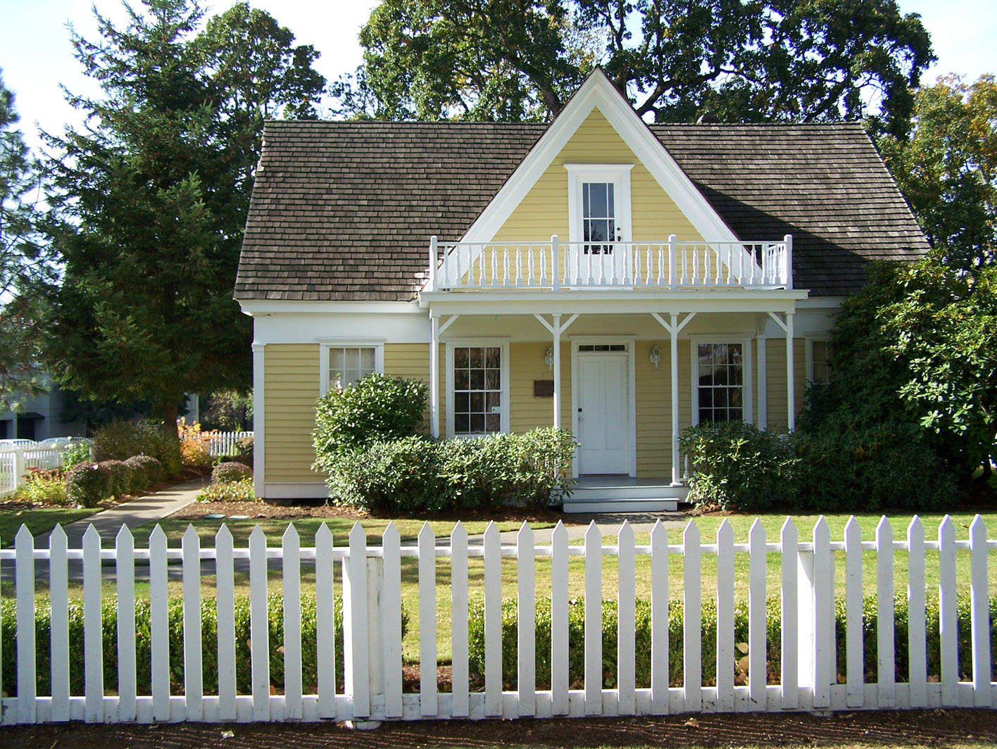 Pastel house with a white trim and picket fence