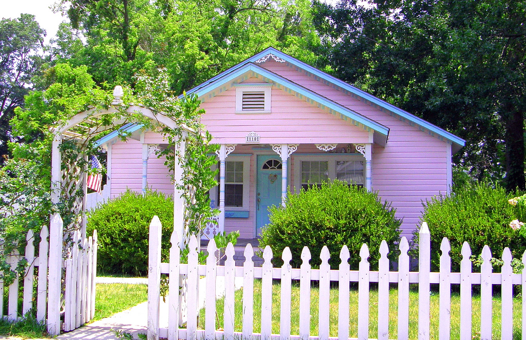 Pink house with a white picket fence