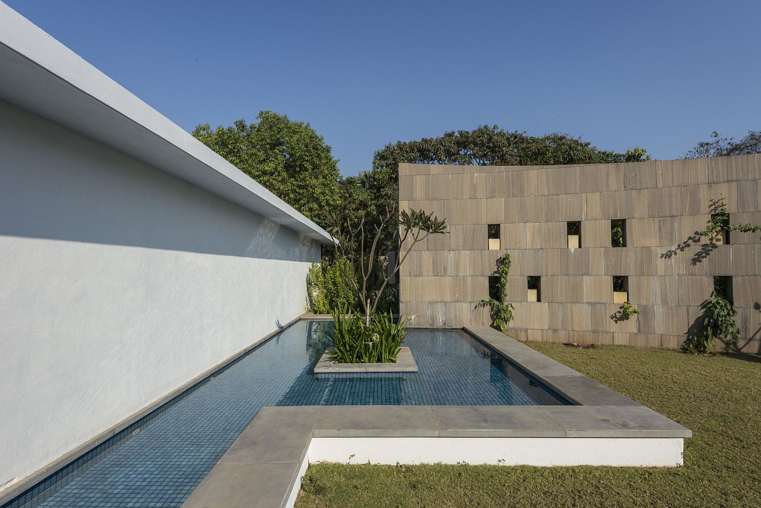 Pool area of the home with curved stone wall