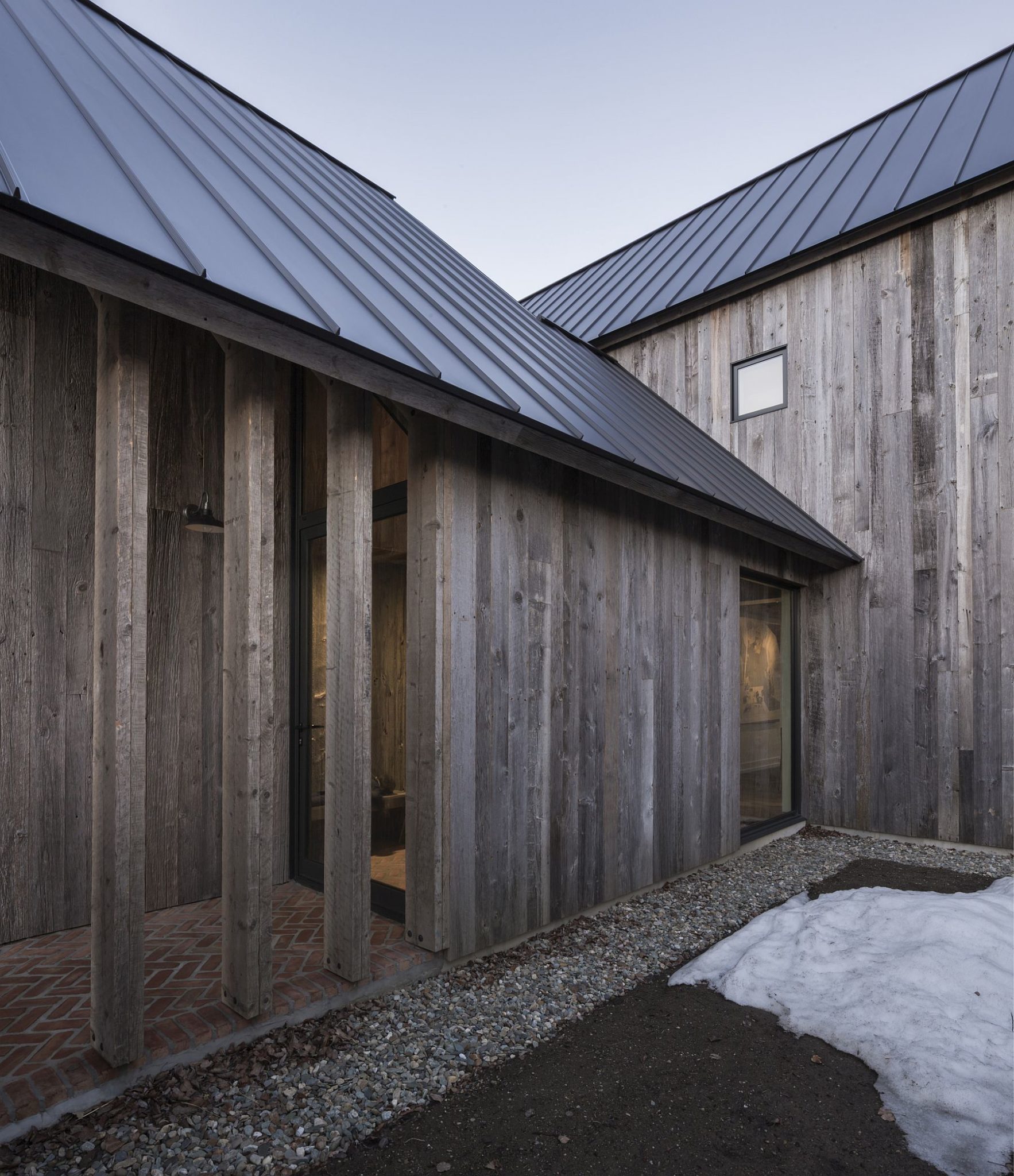 Sheltered walkways around the modern Quebec farmhouse