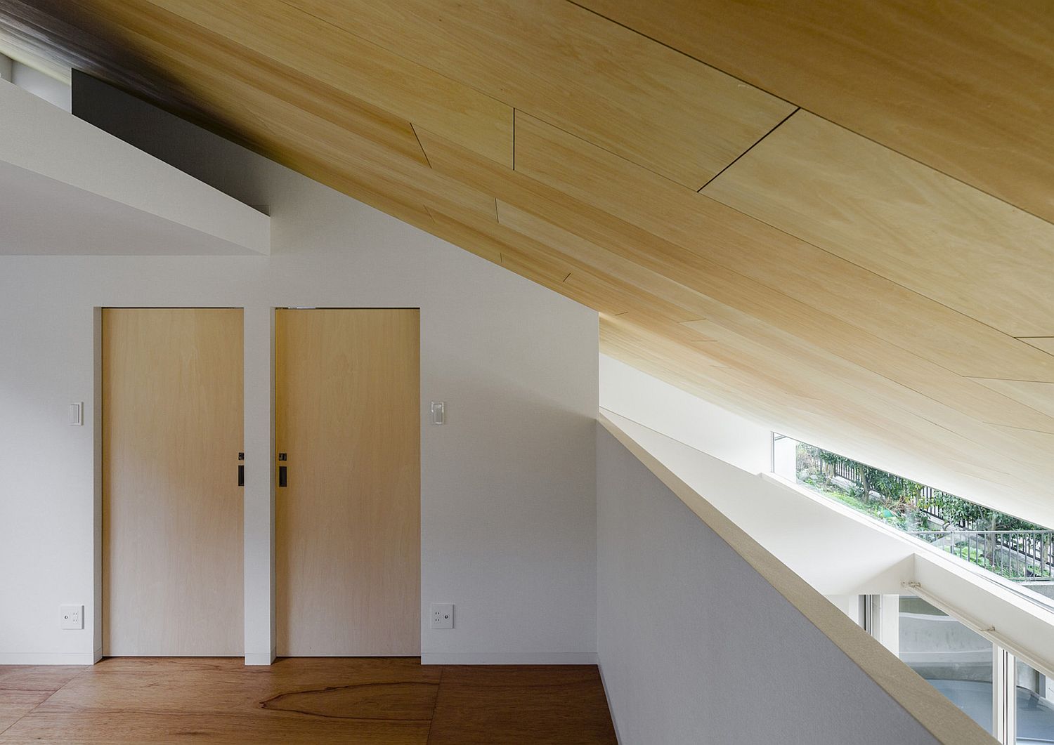 Slanted wooden ceiling of the house adds uniqueness to the home