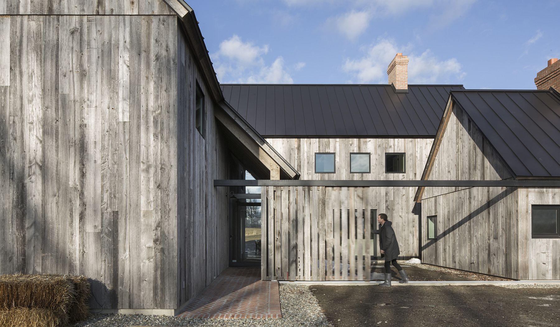 Sliding barn doors and wooden fences provide privacy and protection at the farmhouse