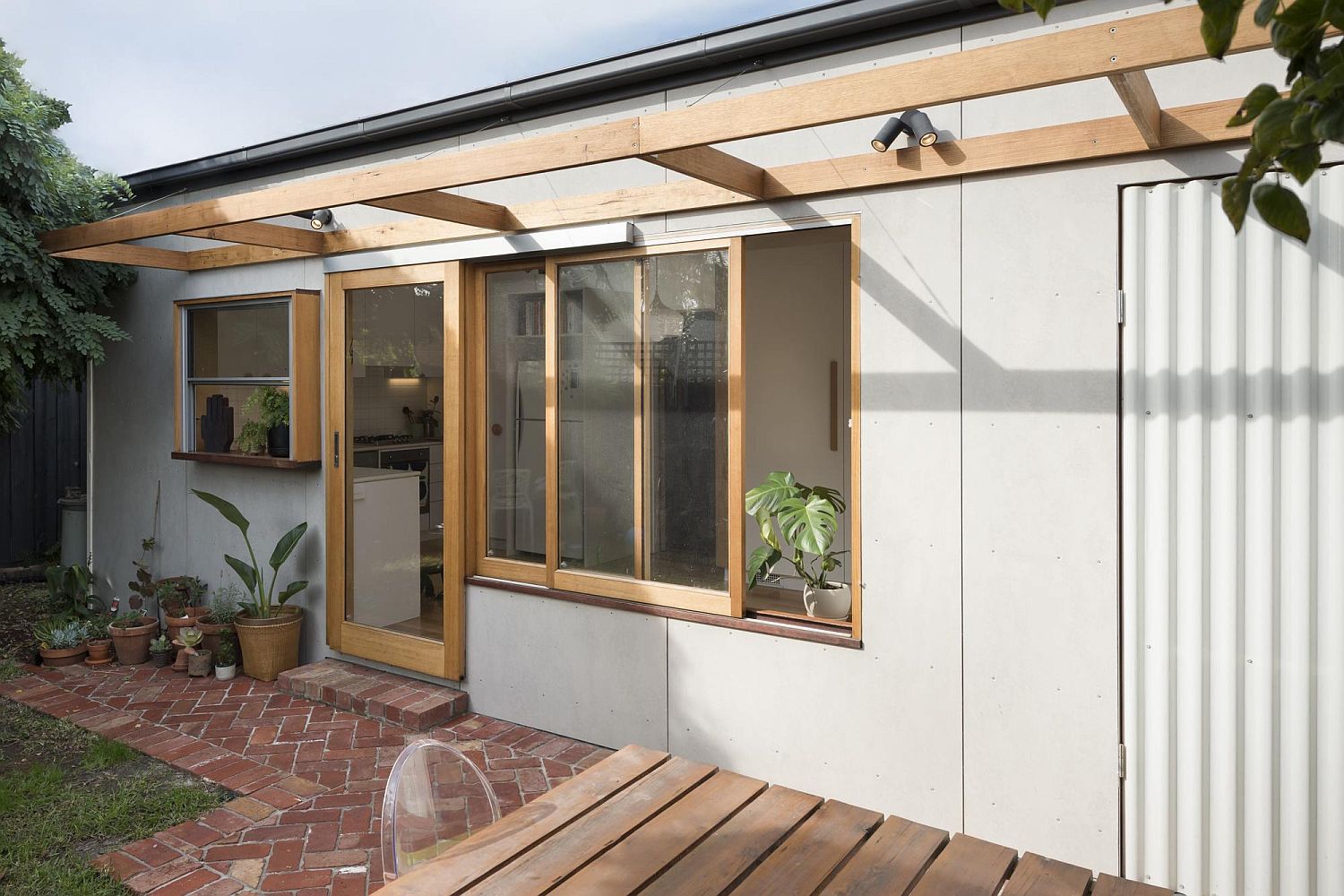 Sliding glass doors and windows connect the rear yard with the new addition