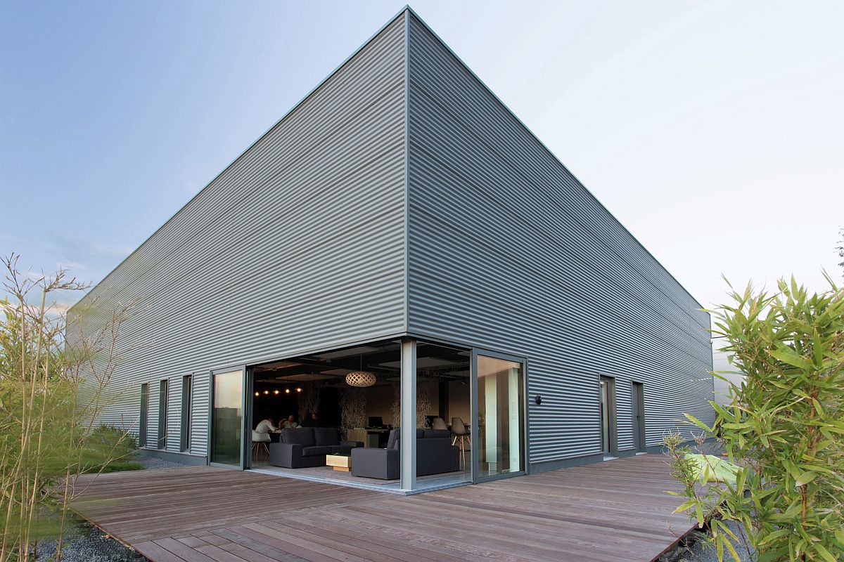 Sliding glass doors in the corner open the interior to the wooden deck