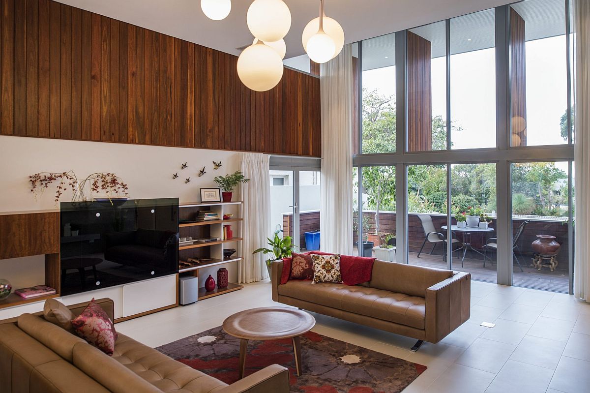 Sweeping windows and glass doors connect the double height interior with the view outside