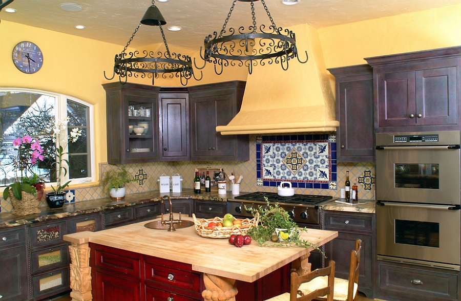 Warm and inviting Mediterranean style kitchen with yellow walls and a wooden island in red