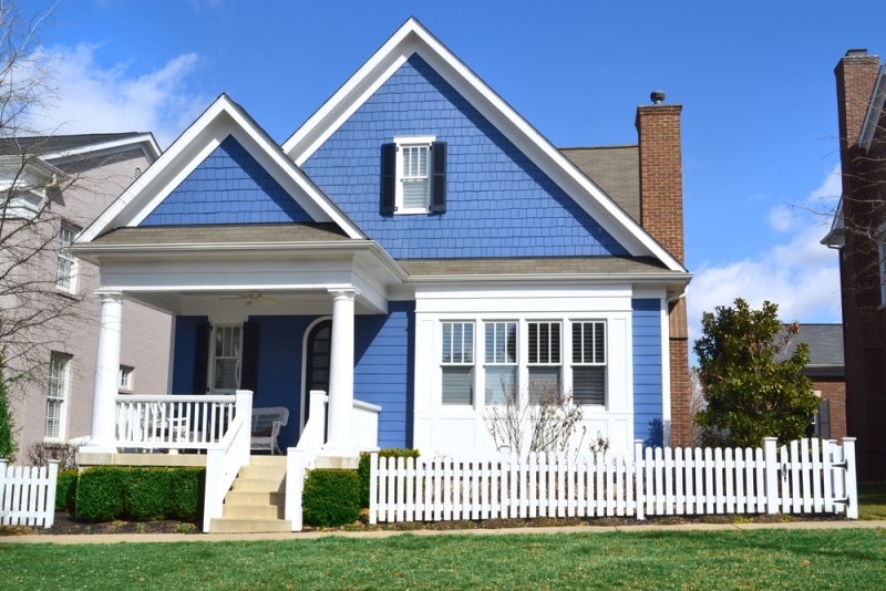 White picket fence makes the blue home stand out