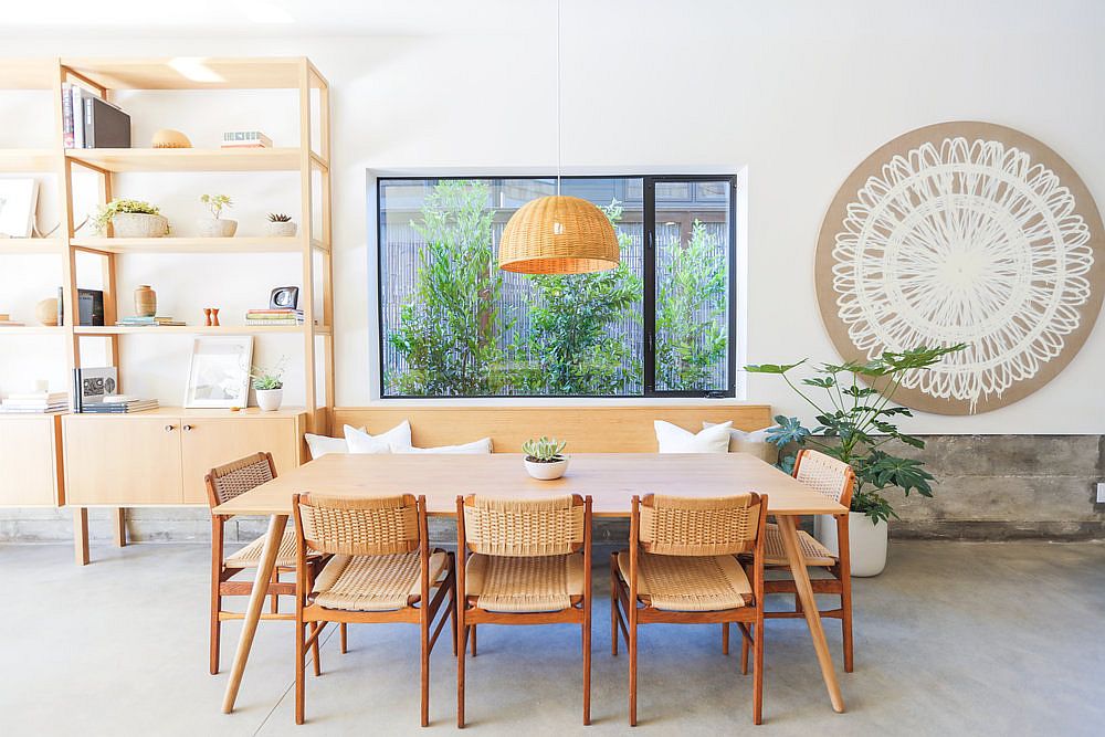 Wooden dining table, chairs and pendant light in natural materials creates a cozy visual