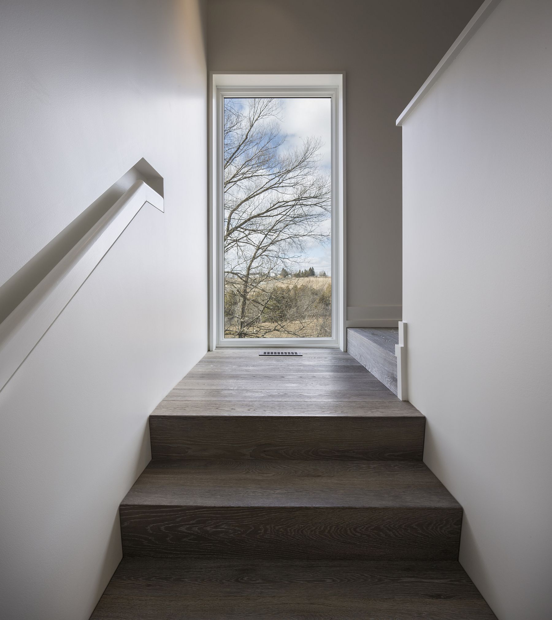 Wooden stairway inside the modern Canadian farmhouse