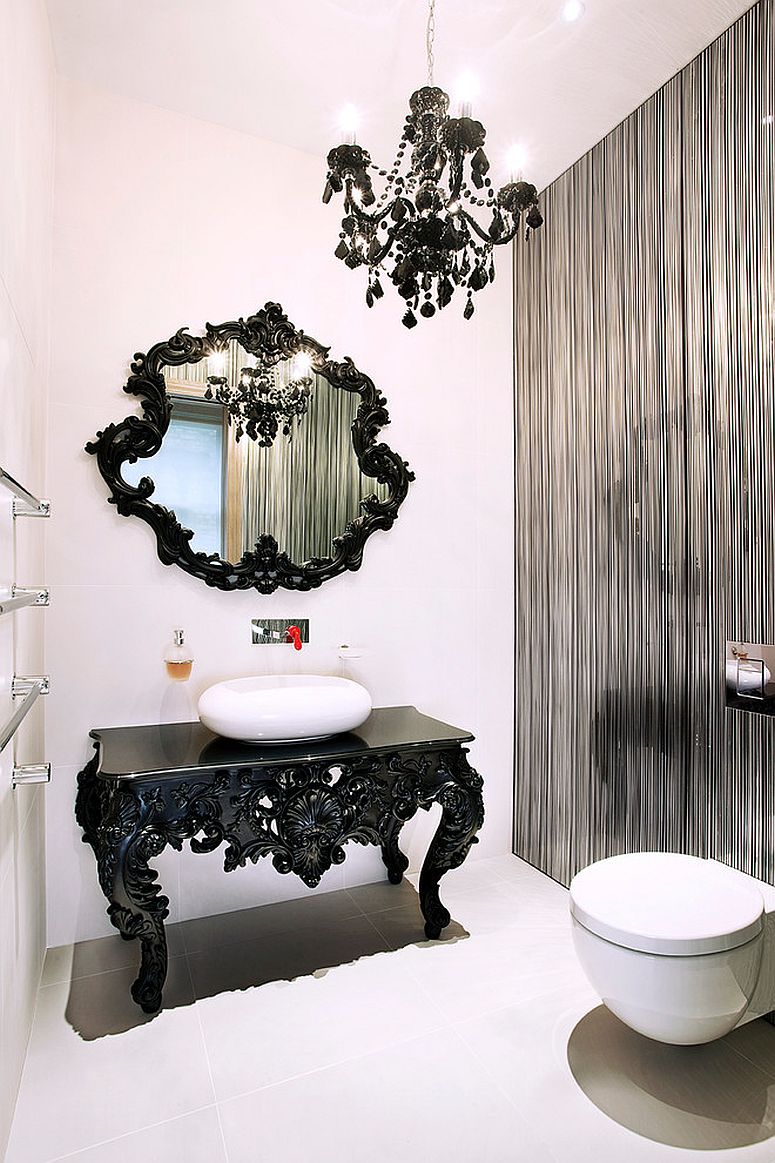 Beautifully crafted black table with ornate design acts as vanity in this glamorous powder room