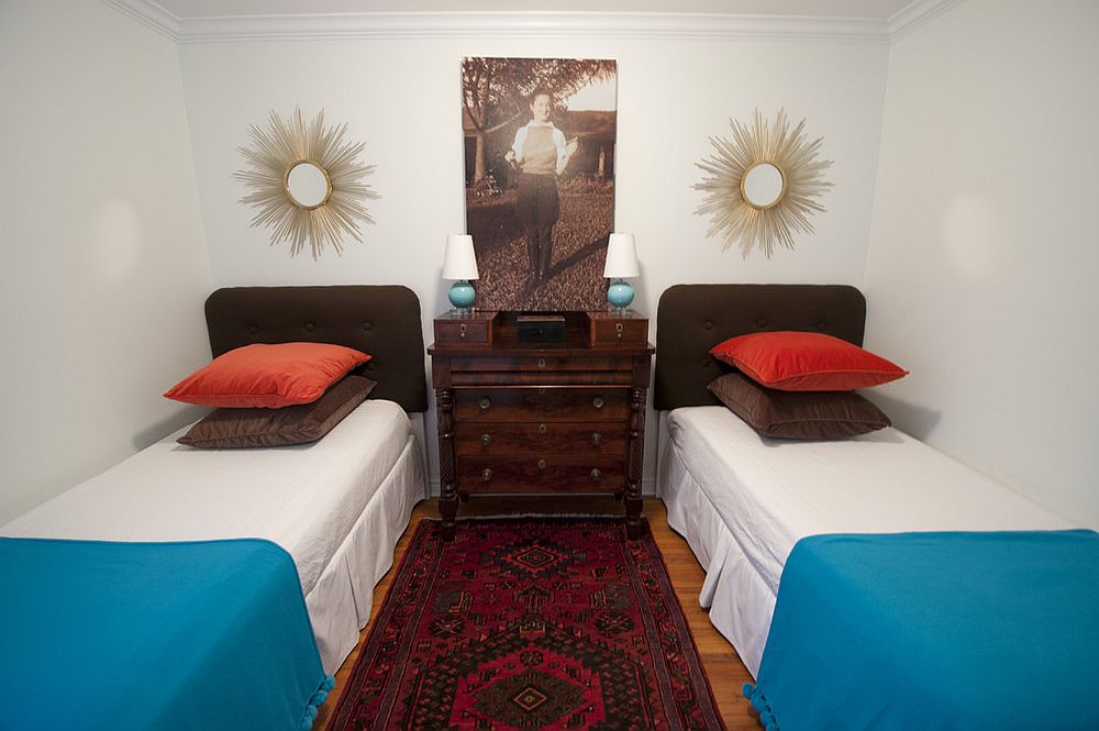 Bedding and carpet bring color to this small guest bedroom in white with twin beds