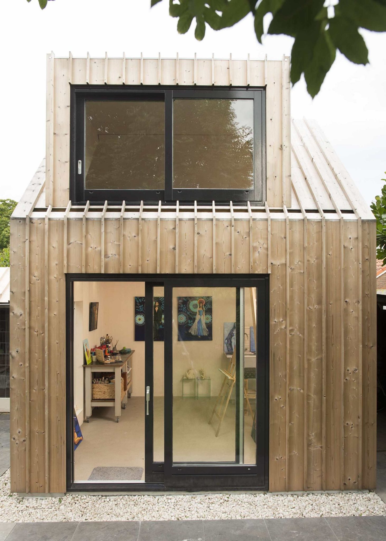 Black-framed doors and windows anchor the light, breezy structure