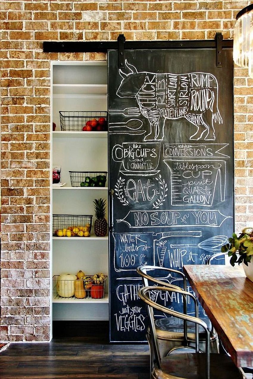 Chalkboard sliding wall next to brick walls creates a cool pantry