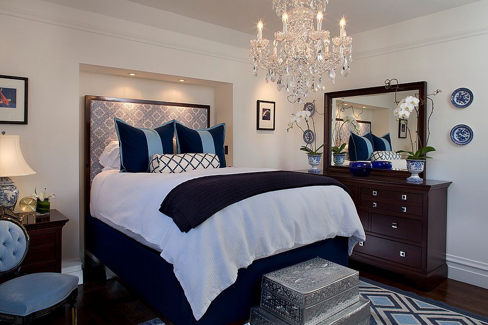 Contemporary bedroom in white and blue with a traditional chandelier