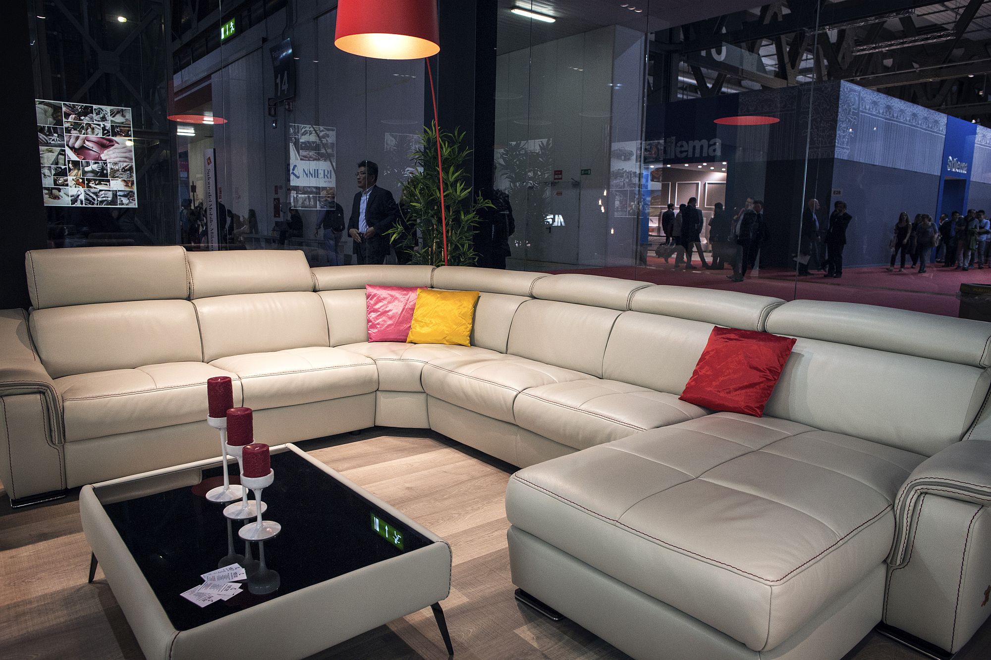 Large white sectional coupled with bright red floor lamp