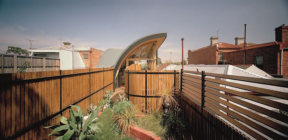 Large wooden fence helps create a green courtyard inside the Melbourne home