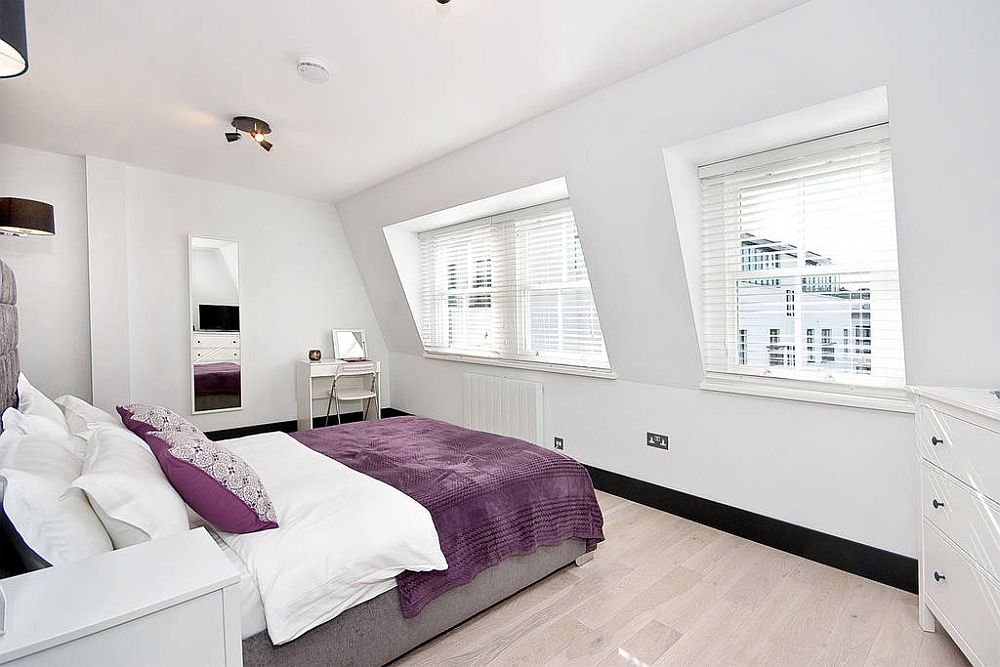 Modern bedroom in white with a small work desk in the corner