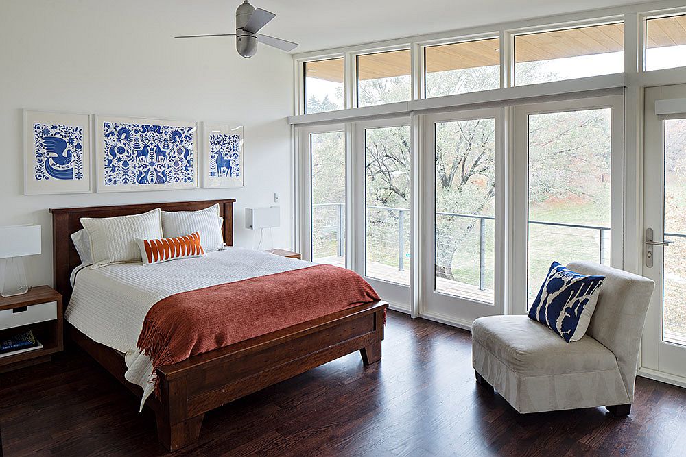 Modern bedroom in white with park views and pops of blue