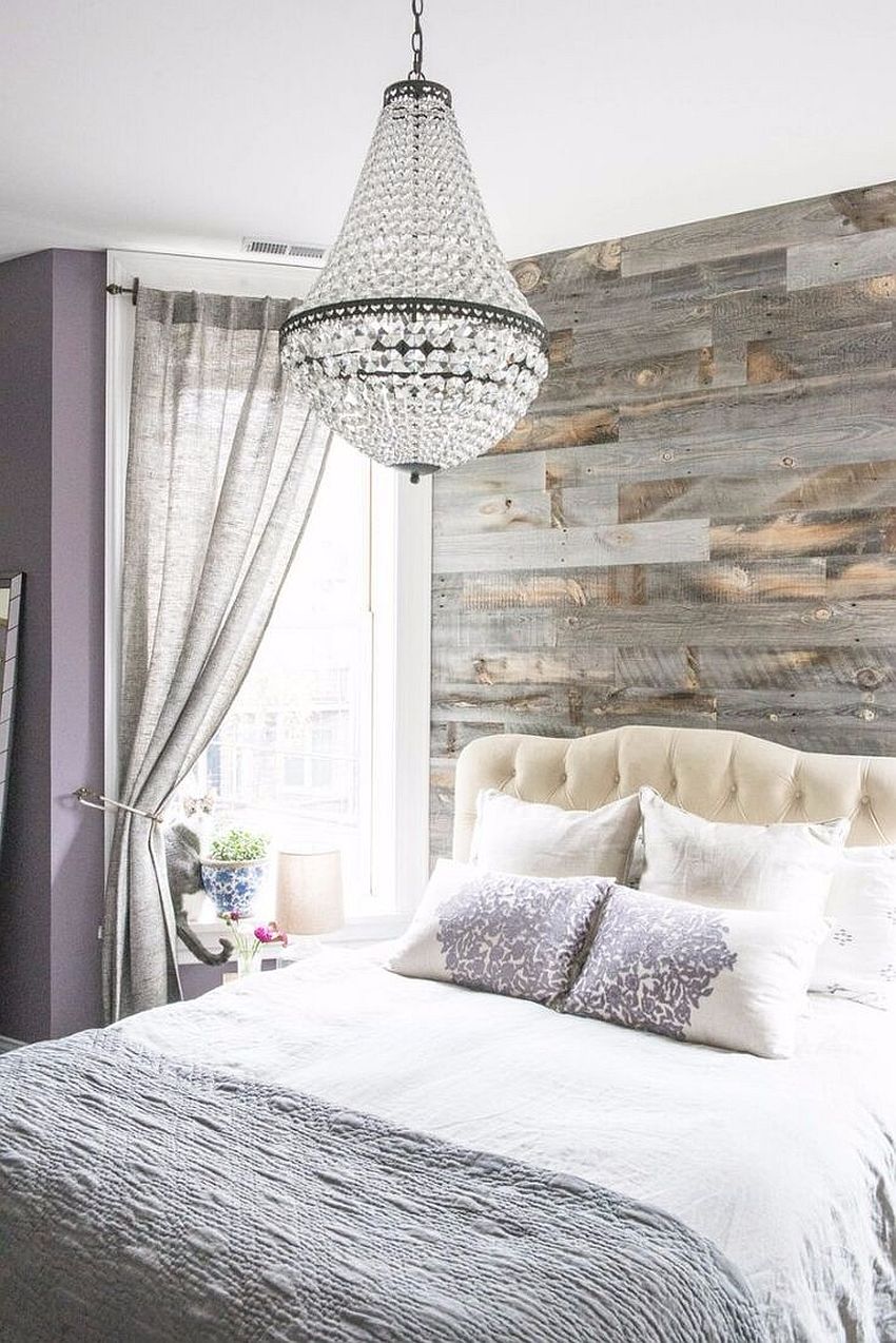 Modern bedroom with a reclaimed wood accent wall and chandelier