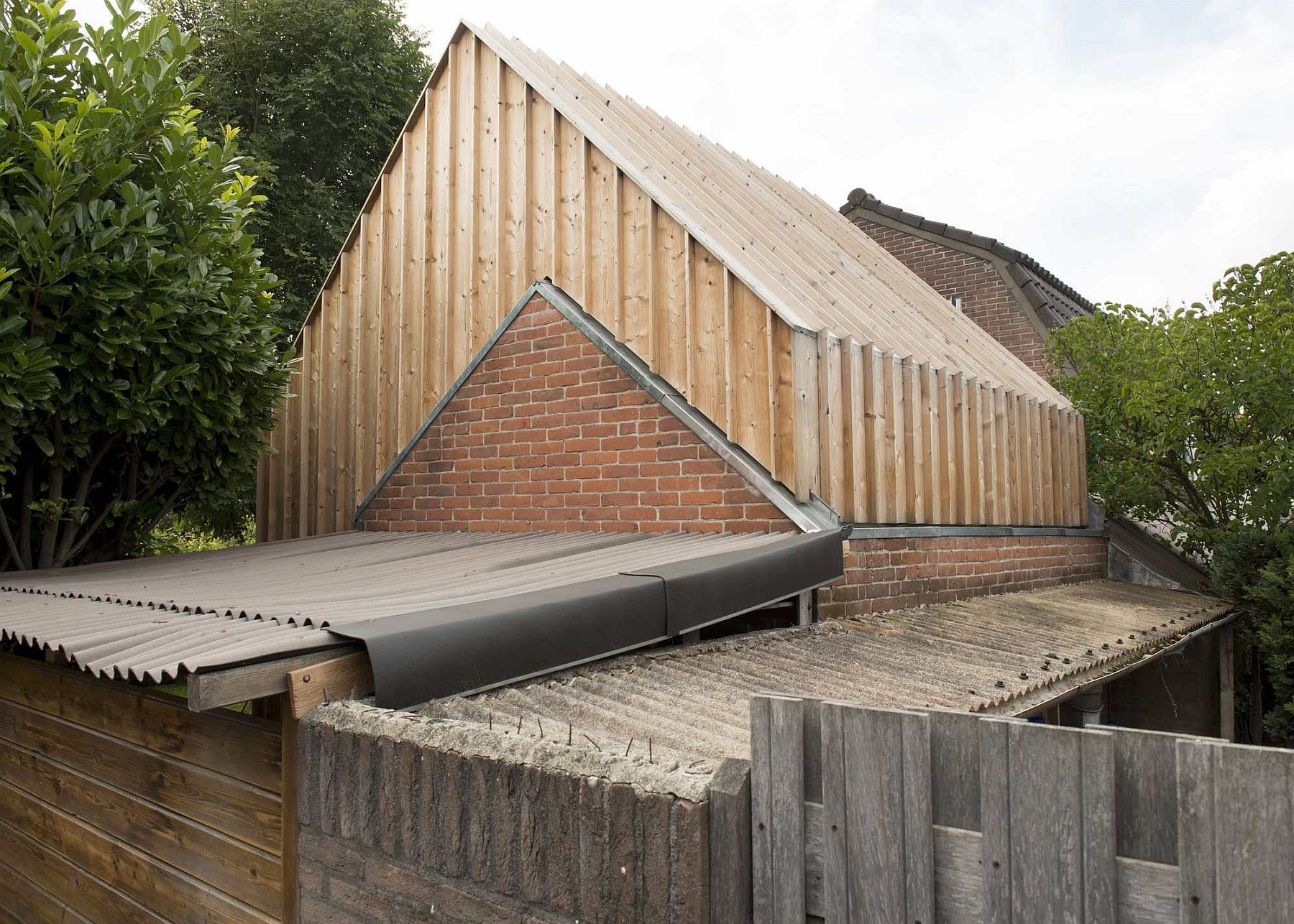 Original brick walls of the old shed are combined with new wooden facade