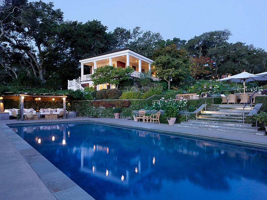 Pergola with gorgeous lighting and relaxing seating next to the pool