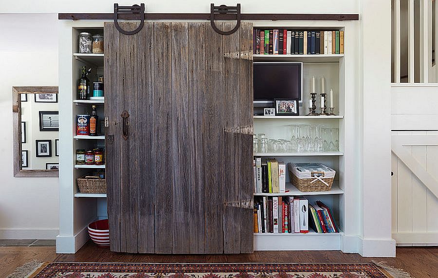 Reclaimed barn door serves as pantry door in this modern kitchen